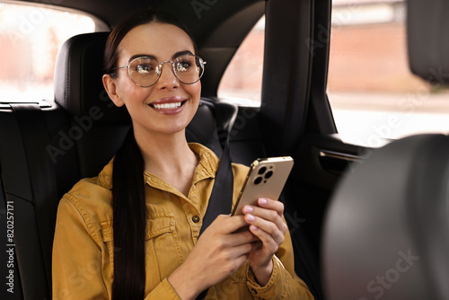 Woman with seatbelt using phone inside car