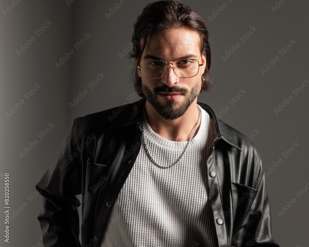 Fototapeta premium portrait of happy sexy man with glasses in leather jacket smiling
