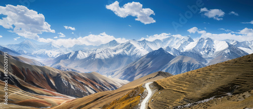 Award Winning national geographic Leading line, a winding mountain path ascends towards a breathtaking, whimsical, ist vista of snow capped peaks and a vast blue sky High Quality, photo