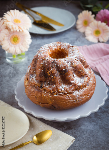 Photography Close up of French Klouglof in a plate with flowers, knife and spoon in background