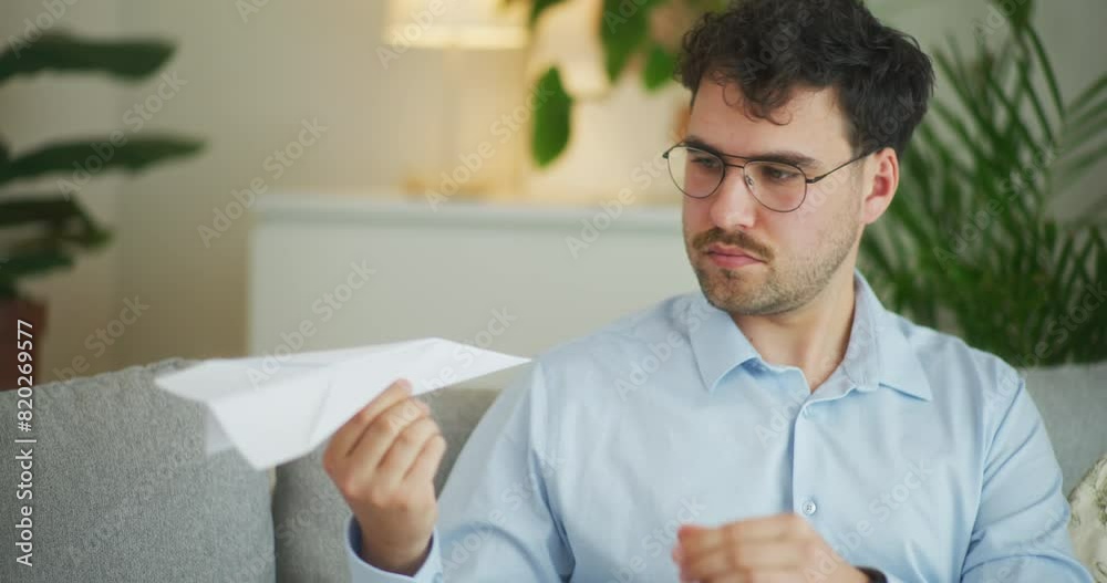 Thoughtful Businessman with Paper Airplane Model Thoughtful Businessman with Paper Airplane Model