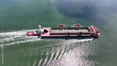 Closeup Aerial view of a dredge container being pushed by a tugboat down the Raritan River in Perth Amboy, New Jersey