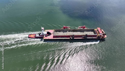 Closeup Aerial view of a dredge container being pushed by a tugboat down the Raritan River in Perth Amboy, New Jersey photo