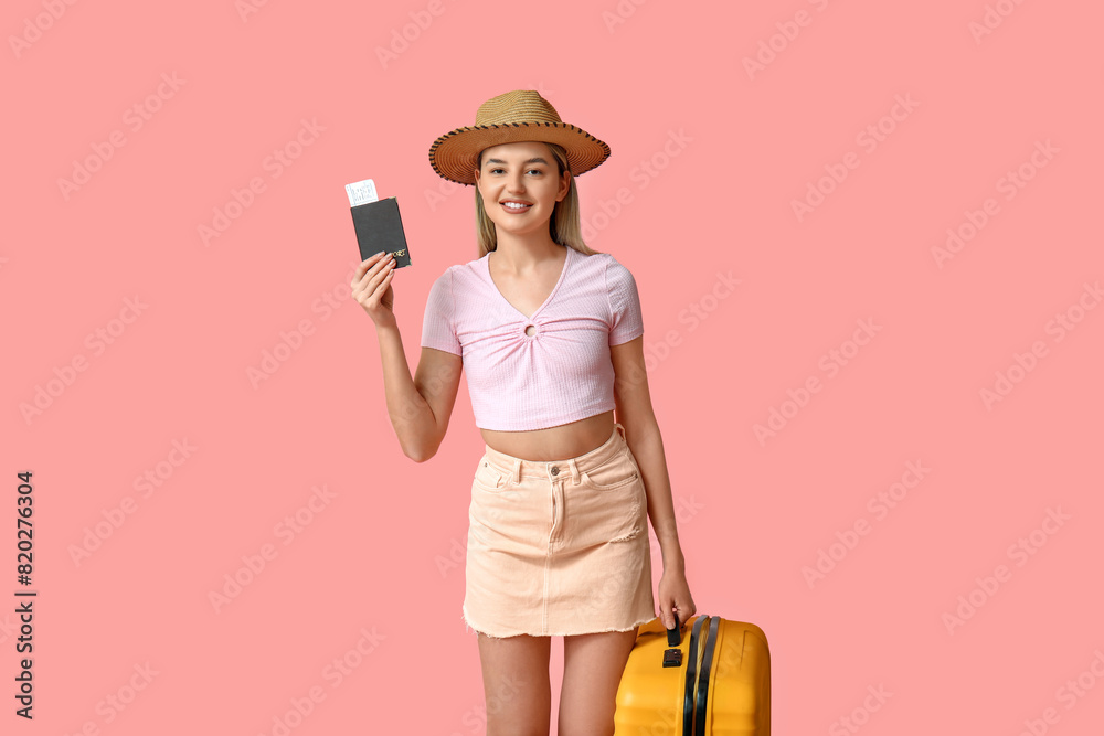 Beautiful young woman with yellow suitcase and passport on pink background. Travel concept Beautiful young woman with yellow suitcase and passport on pink background. Travel concept