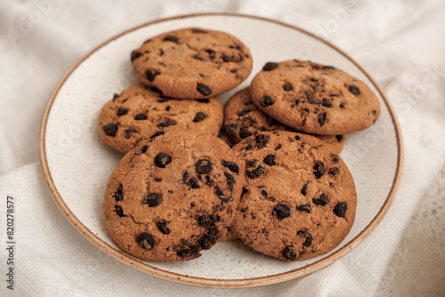 Plate of sweet cookies with chocolate chips on white background  closeup