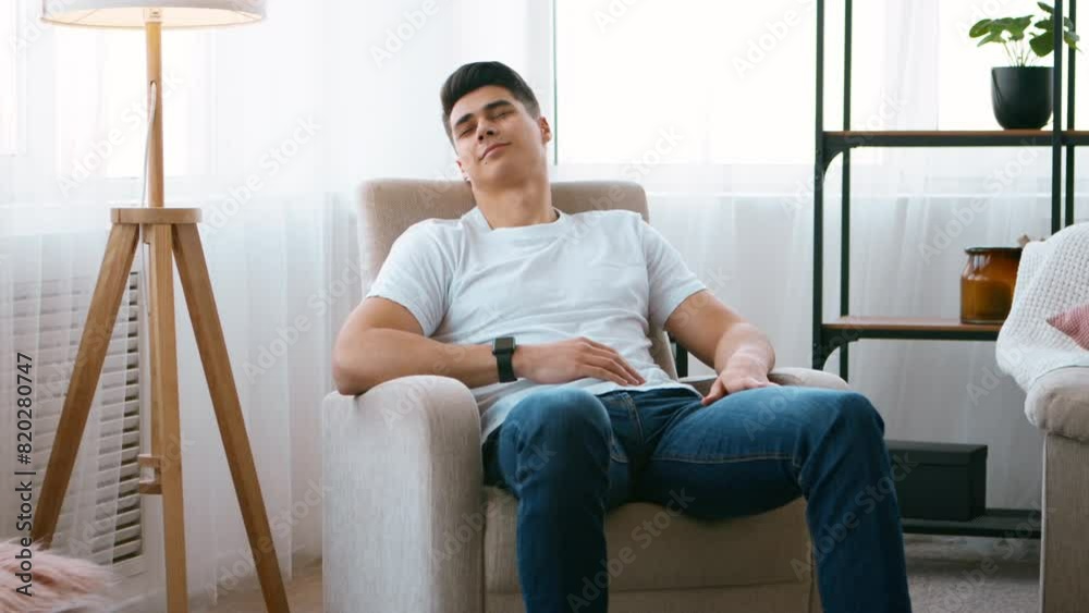 Day sleep. Young man napping on armchair at home interior Day sleep. Young man napping on armchair at home interior