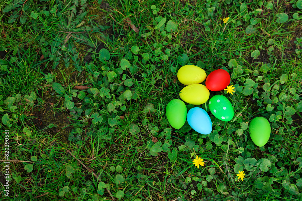 Easter celebration. Painted eggs on green grass, top view. Space for text Easter celebration. Painted eggs on green grass, top view. Space for text