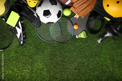 Obraz na plátně Different sports equipment on green grass, flat lay