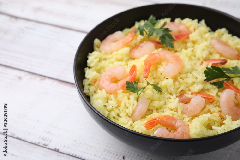 Delicious risotto with shrimps and parsley in bowl on white wooden table, closeup. Space for text Delicious risotto with shrimps and parsley in bowl on white wooden table, closeup. Space for text
