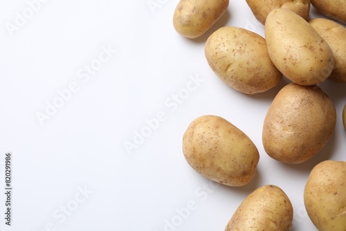 Fresh raw potatoes on white background  flat lay. Space for text