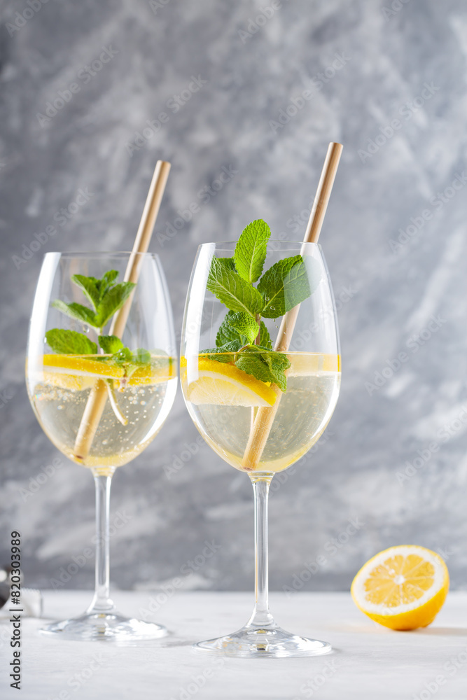 Fototapeta premium Refreshing Hugo Spritz Cocktail with Elderflower Cordial and Sparkling Wine in Glasses on Concrete