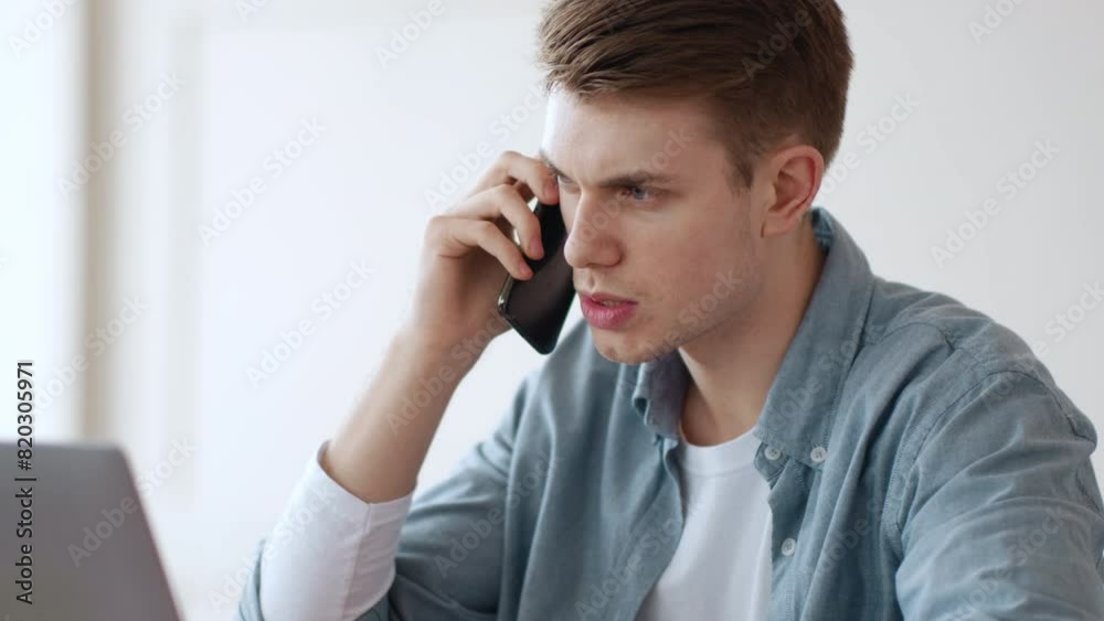  Remote business problems. Serious man entrepreneur communicating with partners by phone from home office