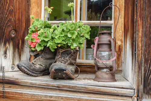 Wanderschuhe und Öllampe als Dekoration an einem Bauernhaus photo