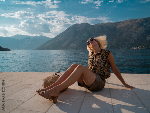 Attractive blonde woman tossing her hair enjoying on the dock by the sea