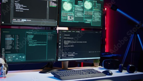 Close up of code running on computer displays in empty apartment used by hacker stealing secrets. Illegal scripts on PC screens used by spy infiltrating governments, handheld camera shot photo