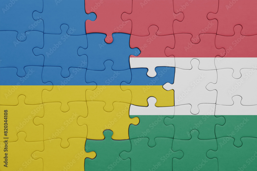 puzzle with the colourful national flag of hungary and flag of ukraine. puzzle with the colourful national flag of hungary and flag of ukraine.
