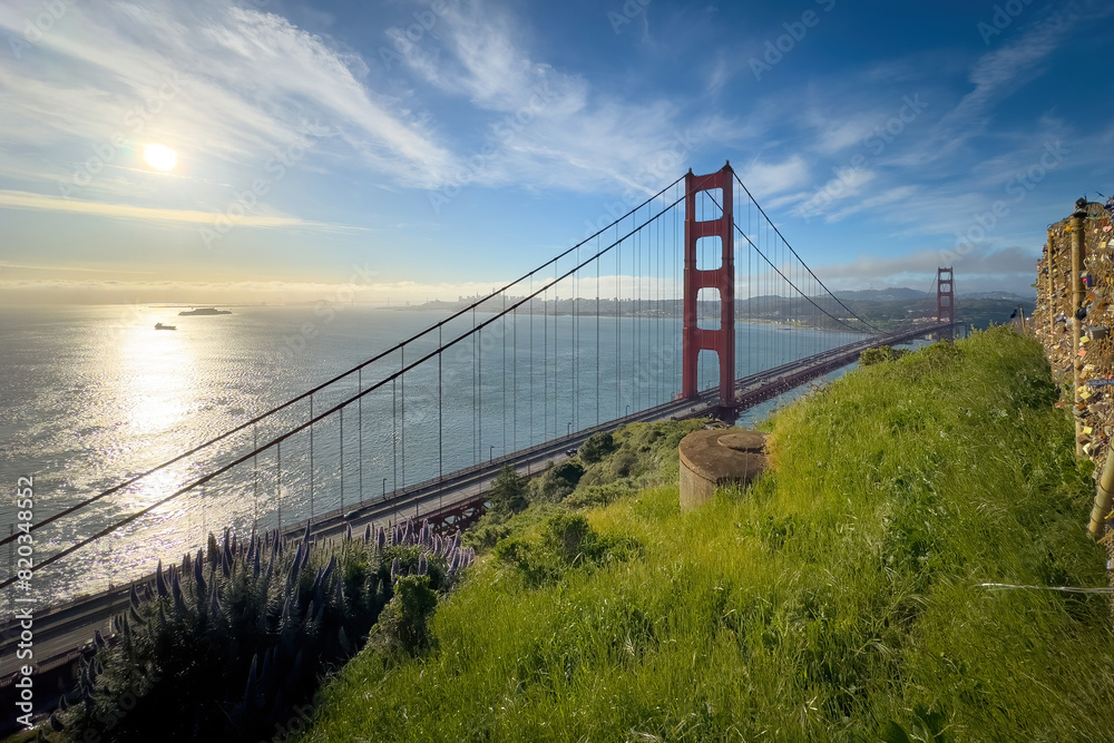 Fototapeta premium Scenic view of Golden Gate Bridge and cityscape of San Francisco, California, USA at sunrise against blue sky with clouds