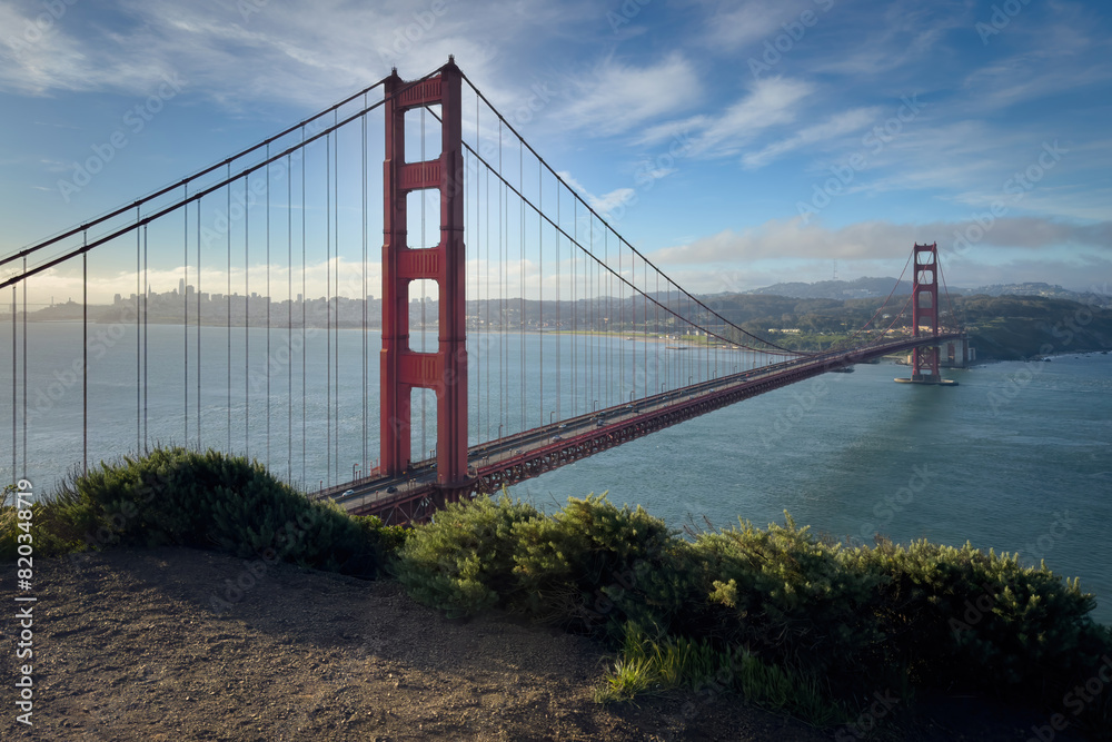 Scenic view of Golden Gate Bridge and cityscape of San Francisco, California, USA at sunrise against blue sky with clouds Scenic view of Golden Gate Bridge and cityscape of San Francisco, California, USA at sunrise against blue sky with clouds