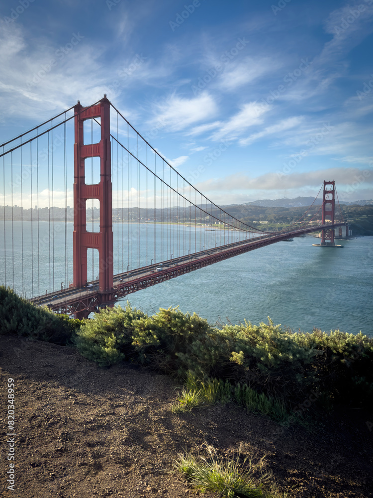 Scenic view of Golden Gate Bridge and cityscape of San Francisco, California, USA at sunrise against blue sky with clouds Scenic view of Golden Gate Bridge and cityscape of San Francisco, California, USA at sunrise against blue sky with clouds