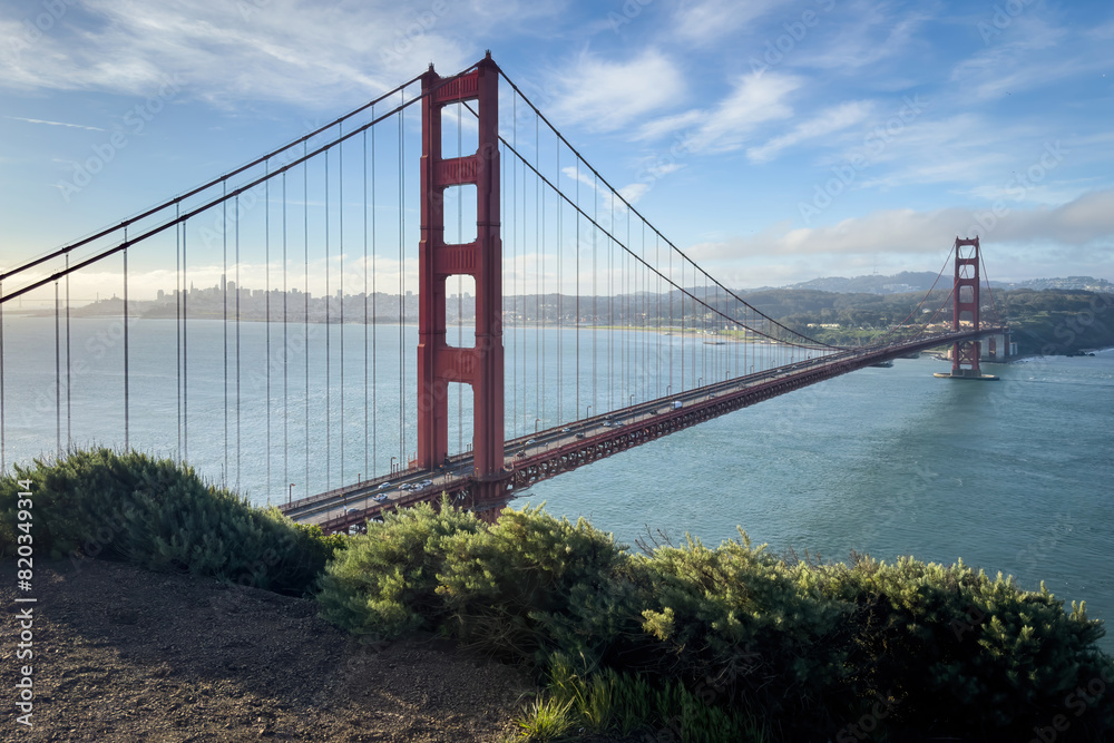 Scenic view of Golden Gate Bridge and cityscape of San Francisco, California, USA at sunrise against blue sky with clouds Scenic view of Golden Gate Bridge and cityscape of San Francisco, California, USA at sunrise against blue sky with clouds