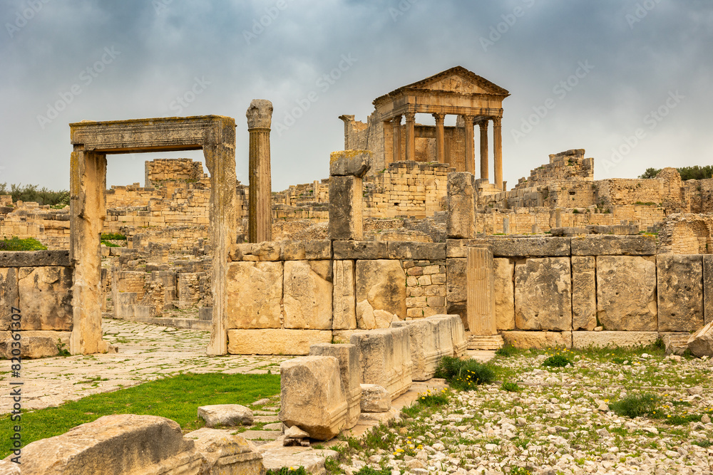 Monumental Capitol surrounded with stone ruins in historical Dougga in the Tebersouk Mountains, Tunisia