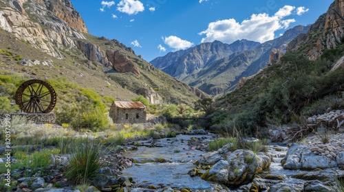 A quaint waterwheel nestled in between two soaring mountains.