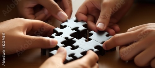 Hands joining puzzle pieces in office businessman teamwork concept