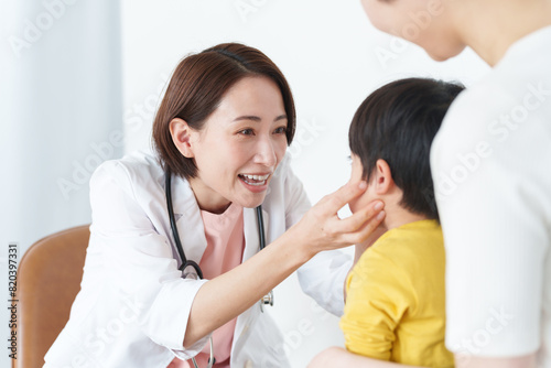 病院で子供の診察をする女性医師
