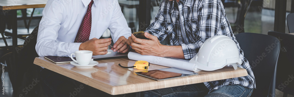 Obraz premium Banner Contractor construction engineer meeting on architect table at construction site. Businessman engineer manager discuss talk together foreman team builder using measure tape with copy space