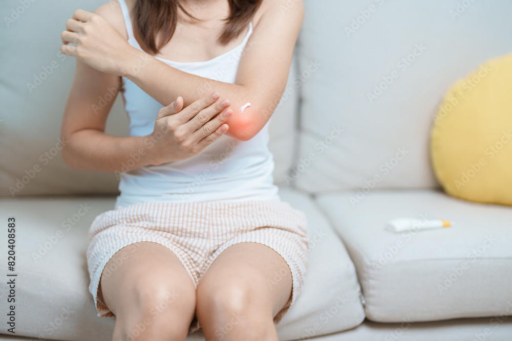 Arthritis and Muscle Pain Relief Cream concept. Woman having elbow ache at home, muscle pain due to lateral epicondylitis or tennis elbow. injury, Health and medical concept Arthritis and Muscle Pain Relief Cream concept. Woman having elbow ache at home, muscle pain due to lateral epicondylitis or tennis elbow. injury, Health and medical concept