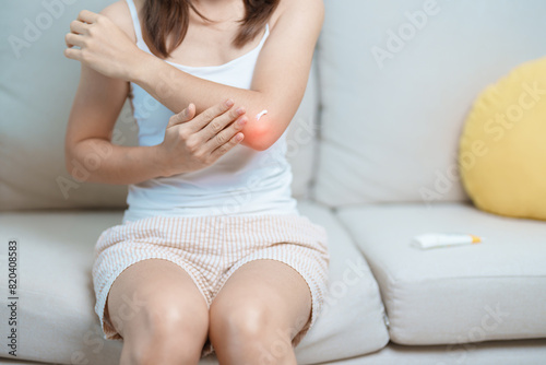 Arthritis and Muscle Pain Relief Cream concept. Woman having elbow ache at home, muscle pain due to lateral epicondylitis or tennis elbow. injury, Health and medical concept