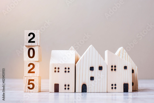 2025 Happy New Year with house model on table wooden background. Banking, real estate, investment, financial, savings and New Year Resolution concepts