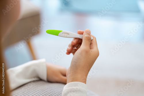 young woman hold in hands positive or negative pregnancy test thinking pondering, millennial female expecting baby undergo fertility infertility treatment