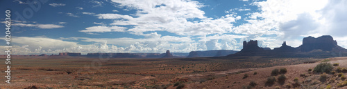 Monument valley wide panoramic view on sunny day, distant buttes and mesa rock formations, contrast contour