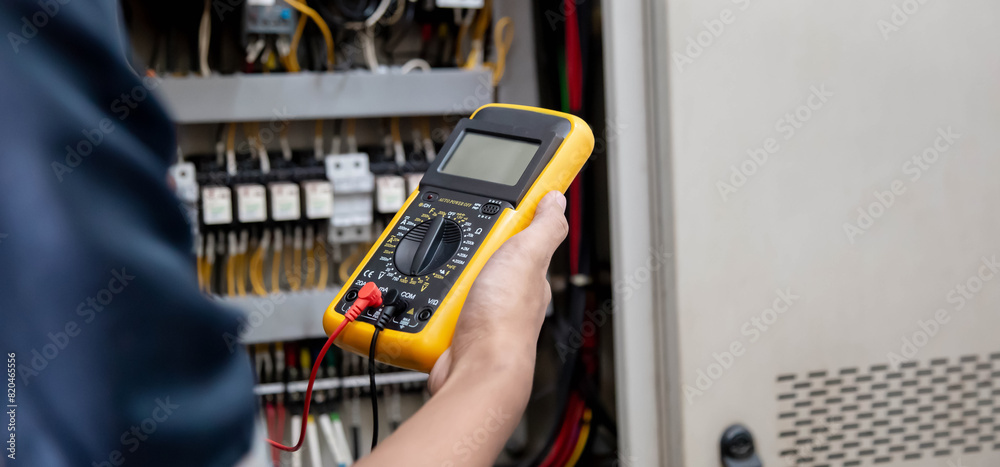Engineer testing electrical system Using a multimeter to measure the ...