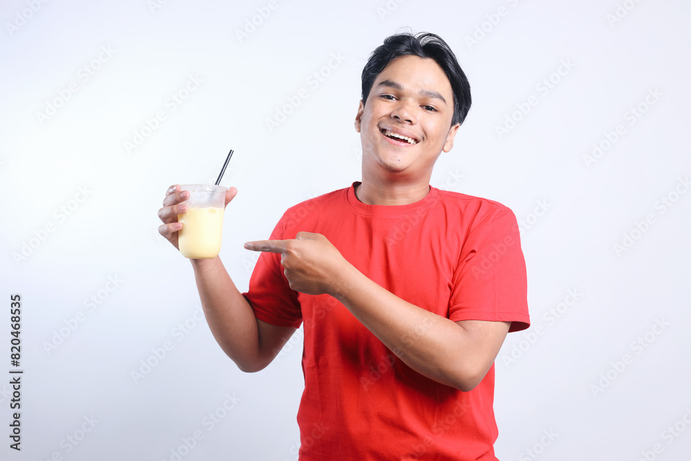 Cheerful Young Asian Man Pointing Juice Drinks Isolated On White Background. Cheerful Young Asian Man Pointing Juice Drinks Isolated On White Background.