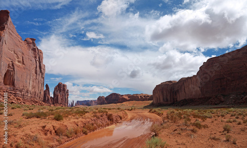 Driving by Loop Road in Monument Valley, Rain god and Thunderbird mesa rocks, nice clouds above, panoramic view photo