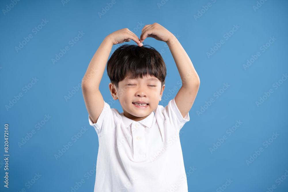 Portrait of asian boy posing on blue background Portrait of asian boy posing on blue background