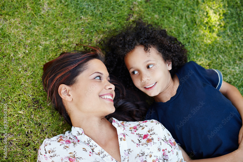 Garden, mom and child lying on grass to relax in summer, vacation or picnic in holiday. Happy, mother and kid on lawn in backyard with smile on face and talking with love or care in family from above Garden, mom and child lying on grass to relax in summer, vacation or picnic in holiday. Happy, mother and kid on lawn in backyard with smile on face and talking with love or care in family from above