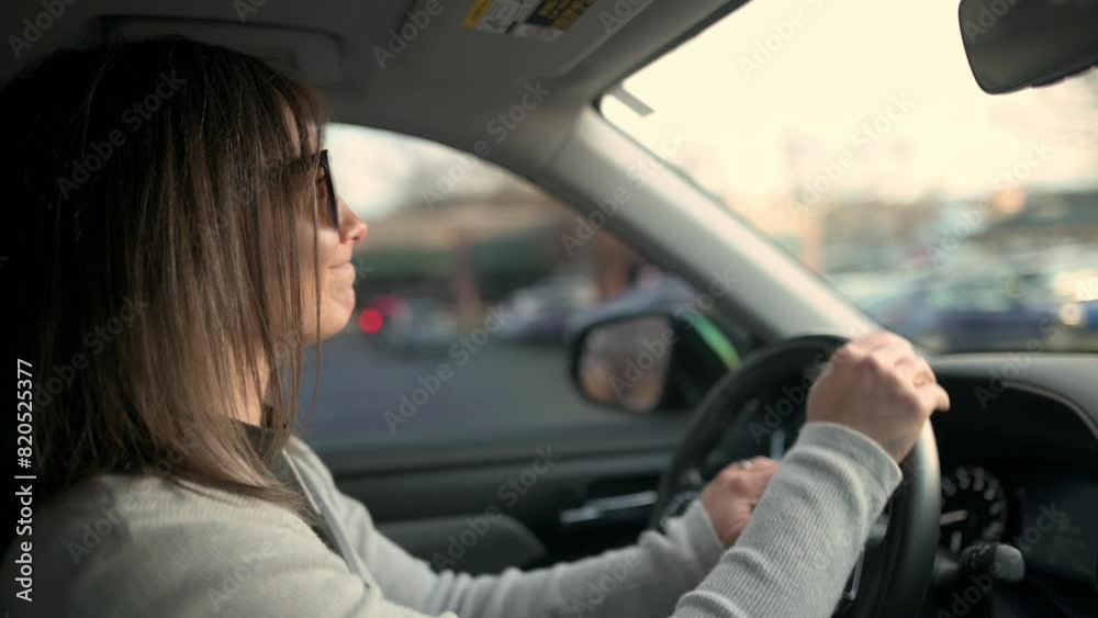 A woman appears nervous as she navigates her car through congested city traffic, capturing the tension and stress often associated with urban commuting A woman appears nervous as she navigates her car through congested city traffic, capturing the tension and stress often associated with urban commuting