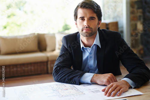 Portrait, business man and serious with blueprint for planning, building design or floor plan on desk. Home office, architecture or male architect for project renovation, real estate or ideas