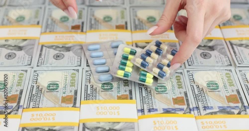 Medical pills and stacks of dollar bills photo