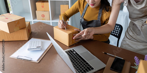 Fotografie Asian women managing shipping logistics for online business