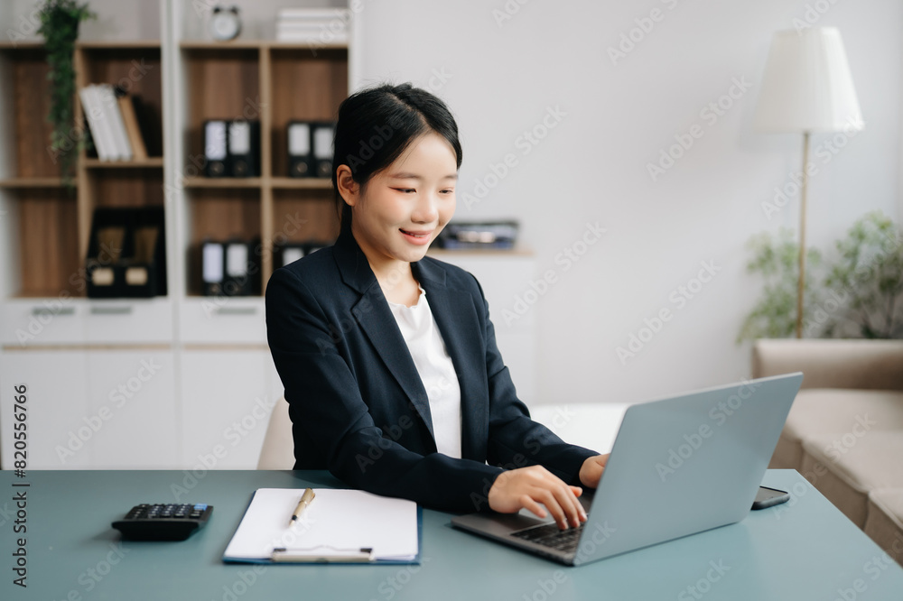 Businesswoman Analyzing Finance on Tablet and Laptop at modern Office Desk tax, report, accounting, statistics, and analytical research concept Businesswoman Analyzing Finance on Tablet and Laptop at modern Office Desk tax, report, accounting, statistics, and analytical research concept