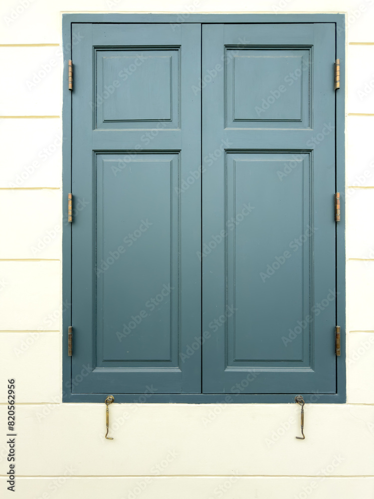Closed wooden window on a white building wall Closed wooden window on a white building wall