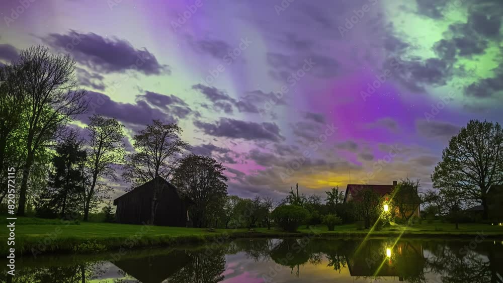 Aurora borealis shine through the clouds in a dreamy time lapse above a countryside cabin Aurora borealis shine through the clouds in a dreamy time lapse above a countryside cabin