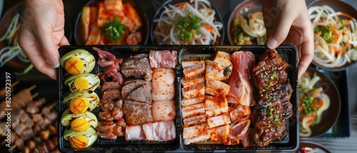 Person s hands presenting a gourmet Korean BBQ package, with a mouth ready to take a bite, ideal for illustrating a rich and flavorful business meal photo