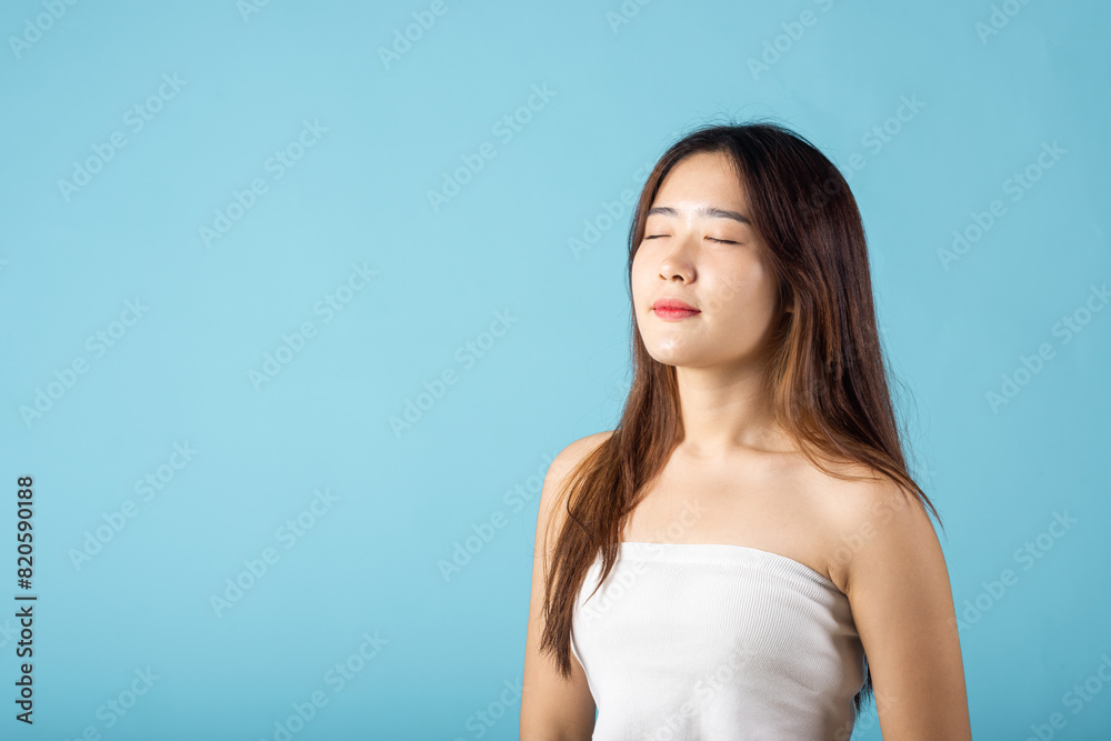 Front portrait of Asian young woman beautiful face closed eyes and smiling studio shot isolated on blue background, close up face of happy female healthy sleeping, beauty care calm and relaxed Front portrait of Asian young woman beautiful face closed eyes and smiling studio shot isolated on blue background, close up face of happy female healthy sleeping, beauty care calm and relaxed