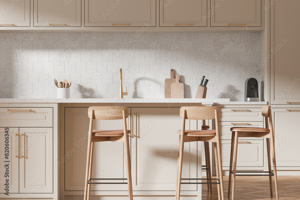 Fototapeta premium Beige kitchen interior with bar countertop and seats, shelves and kitchenware
