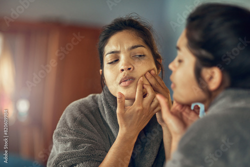 Skincare, mirror and woman pop pimple in bedroom at home for clean or smooth facial treatment. Reflection, cosmetic and upset female person pressing blackhead on face for beauty at apartment.